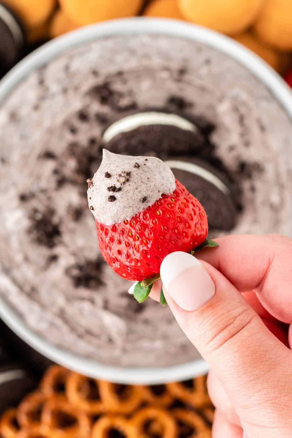 dipping a strawberry into oreo dip