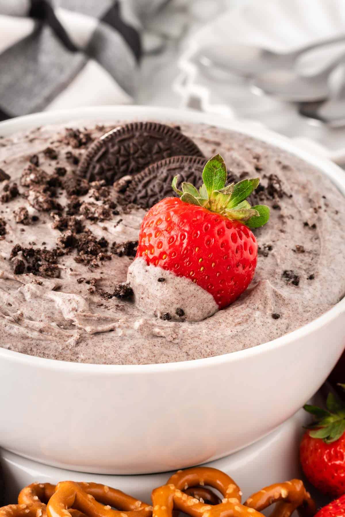 dipping a strawberry into oreo dip