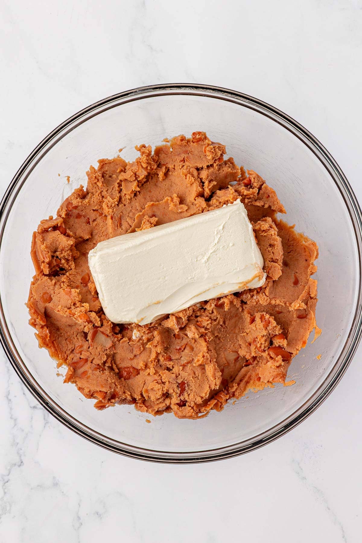 refried beans and cream cheese in a mixing bowl