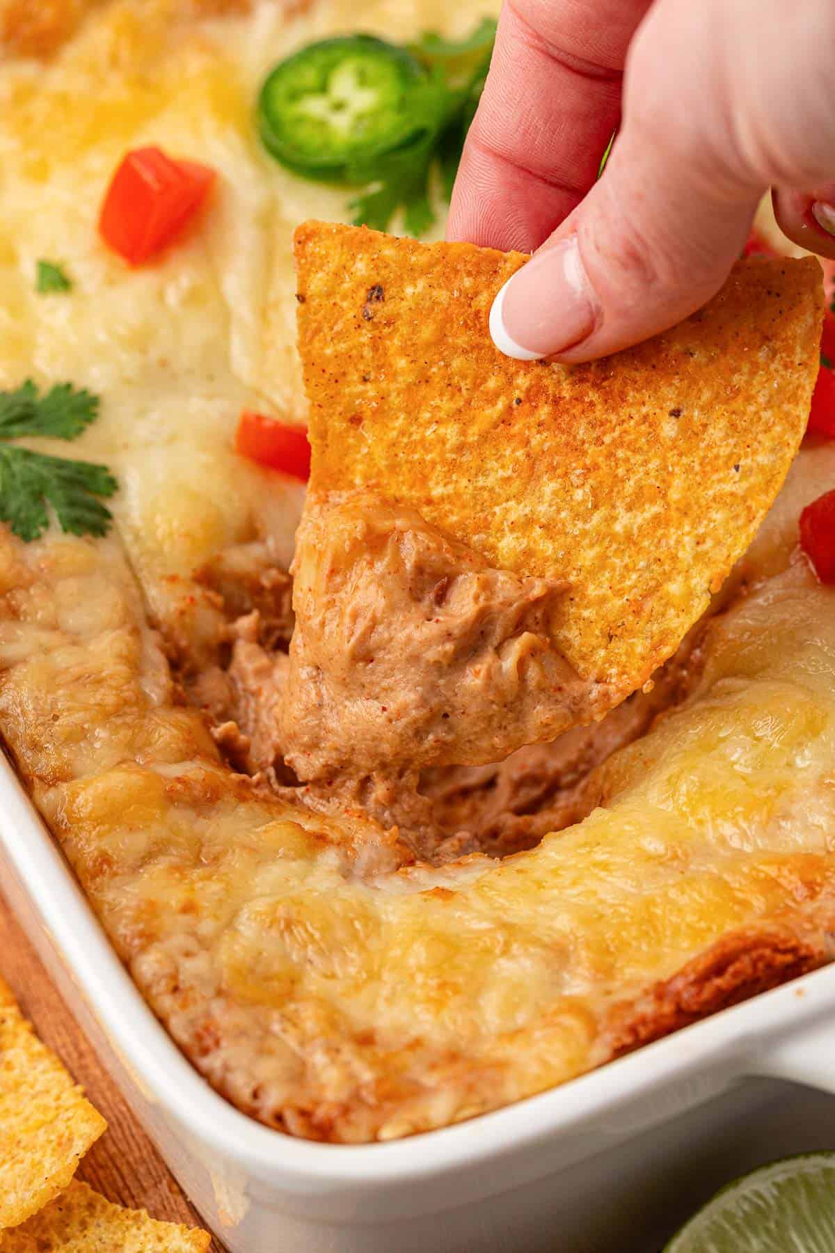 dipping a chip into cream cheese bean dip