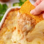 dipping a chip into cream cheese bean dip