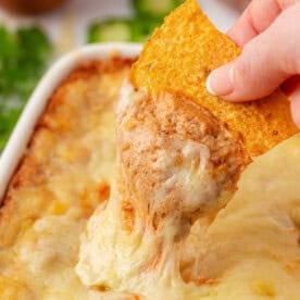 dipping a chip into cream cheese bean dip