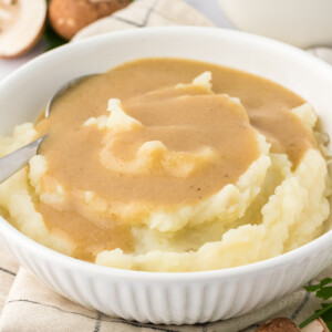 bowl of mashed potatoes topped with vegetarian gravy
