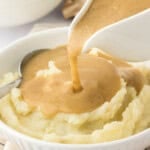 gravy being poured over mashed potatoes