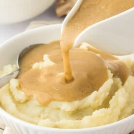 gravy being poured over mashed potatoes