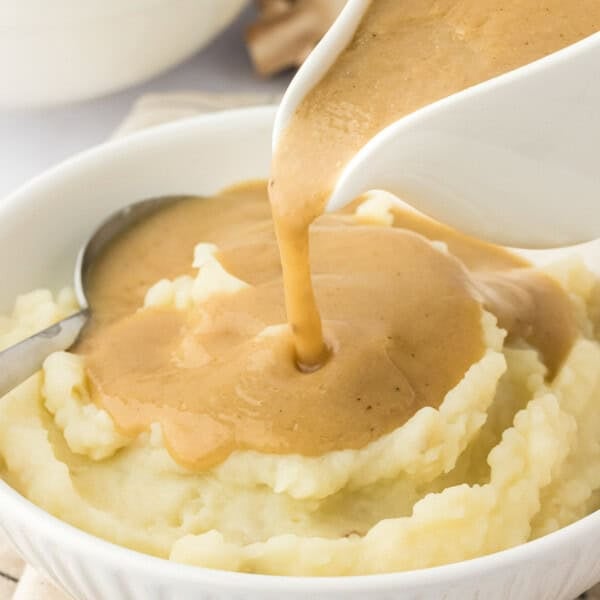 gravy being poured over mashed potatoes