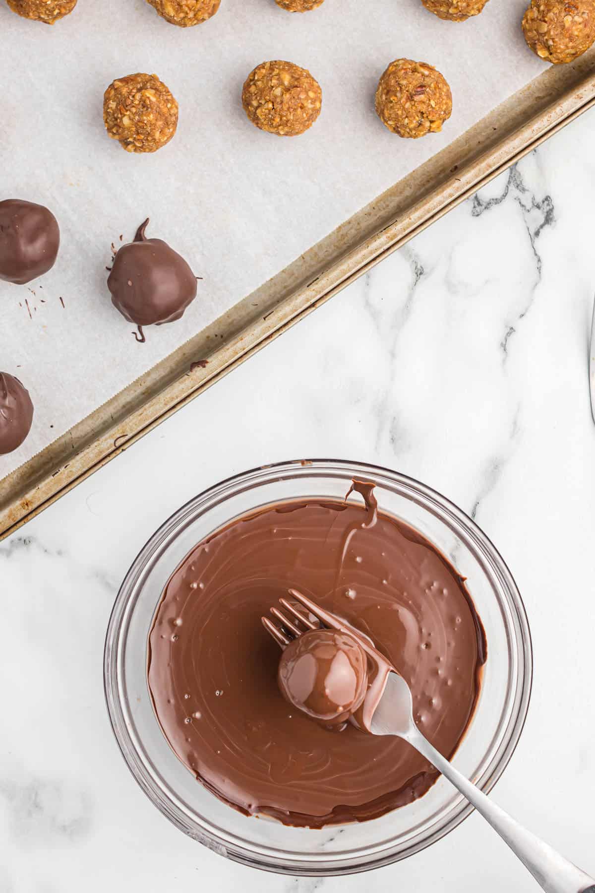 dipping a truffle in melted chocolate