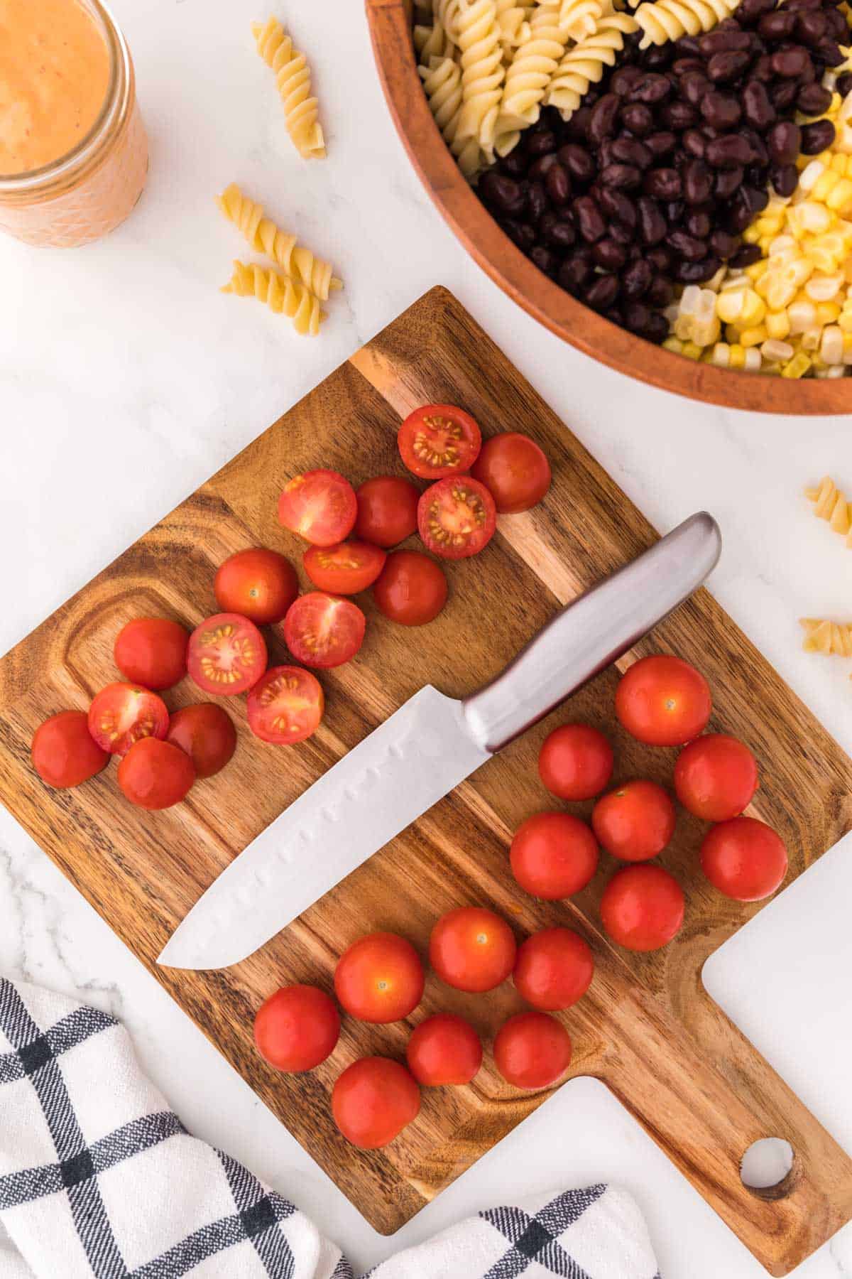 cherry tomatoes cut up on a cutting board