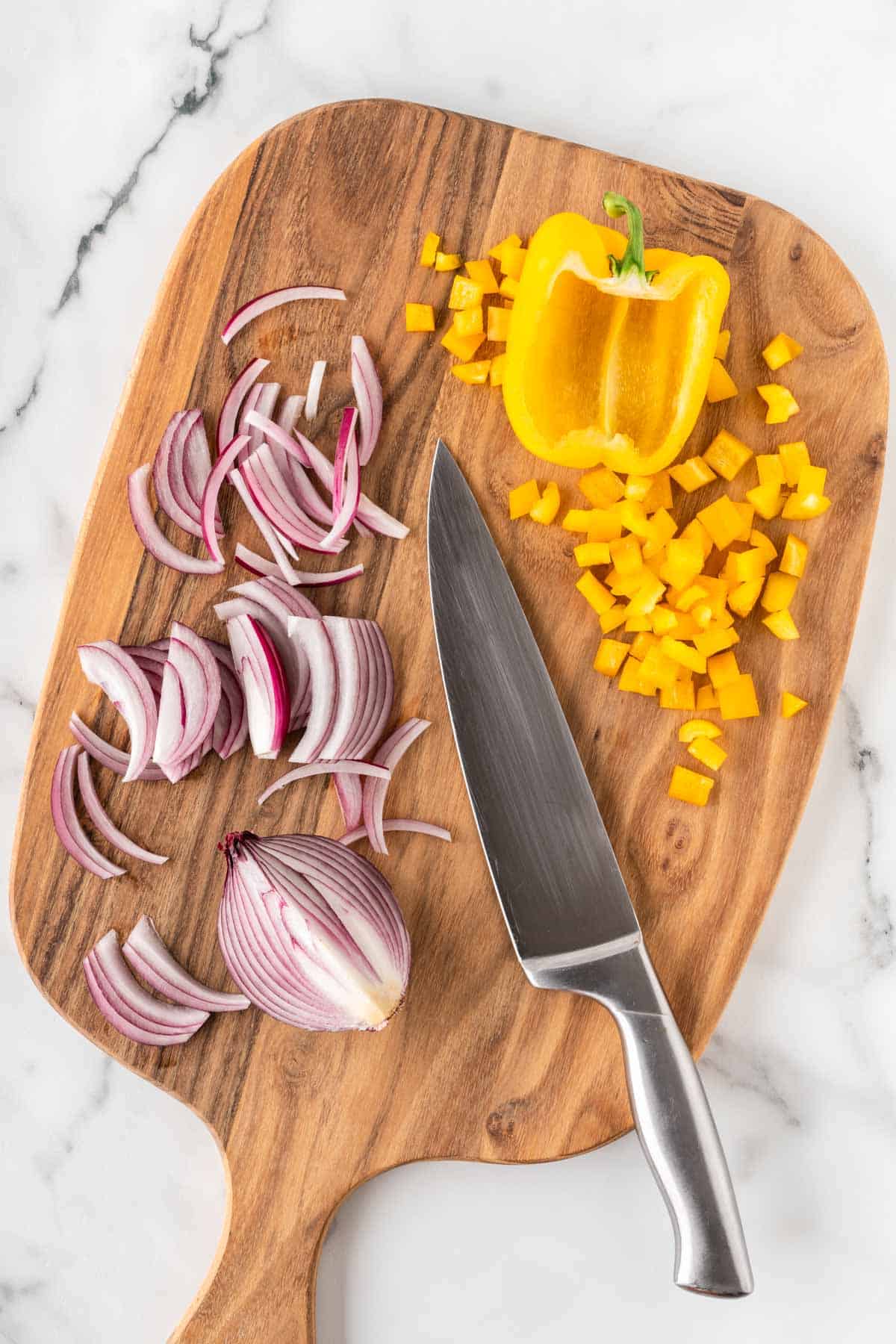 cut up bell pepper and onion on a cutting board