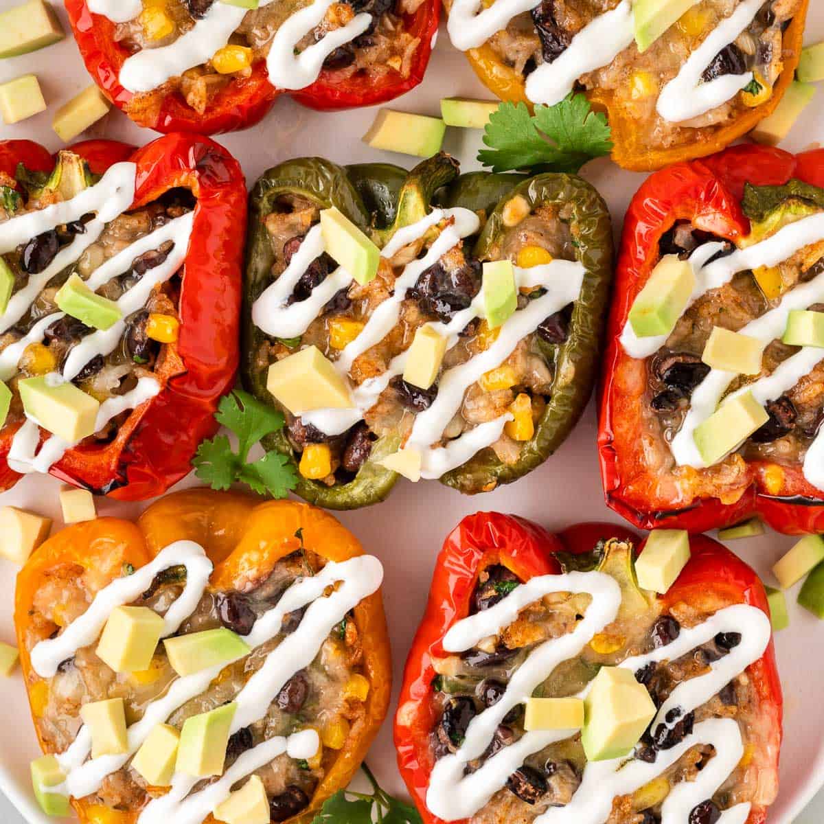 vegetarian stuffed peppers topped with sour cream and avocado