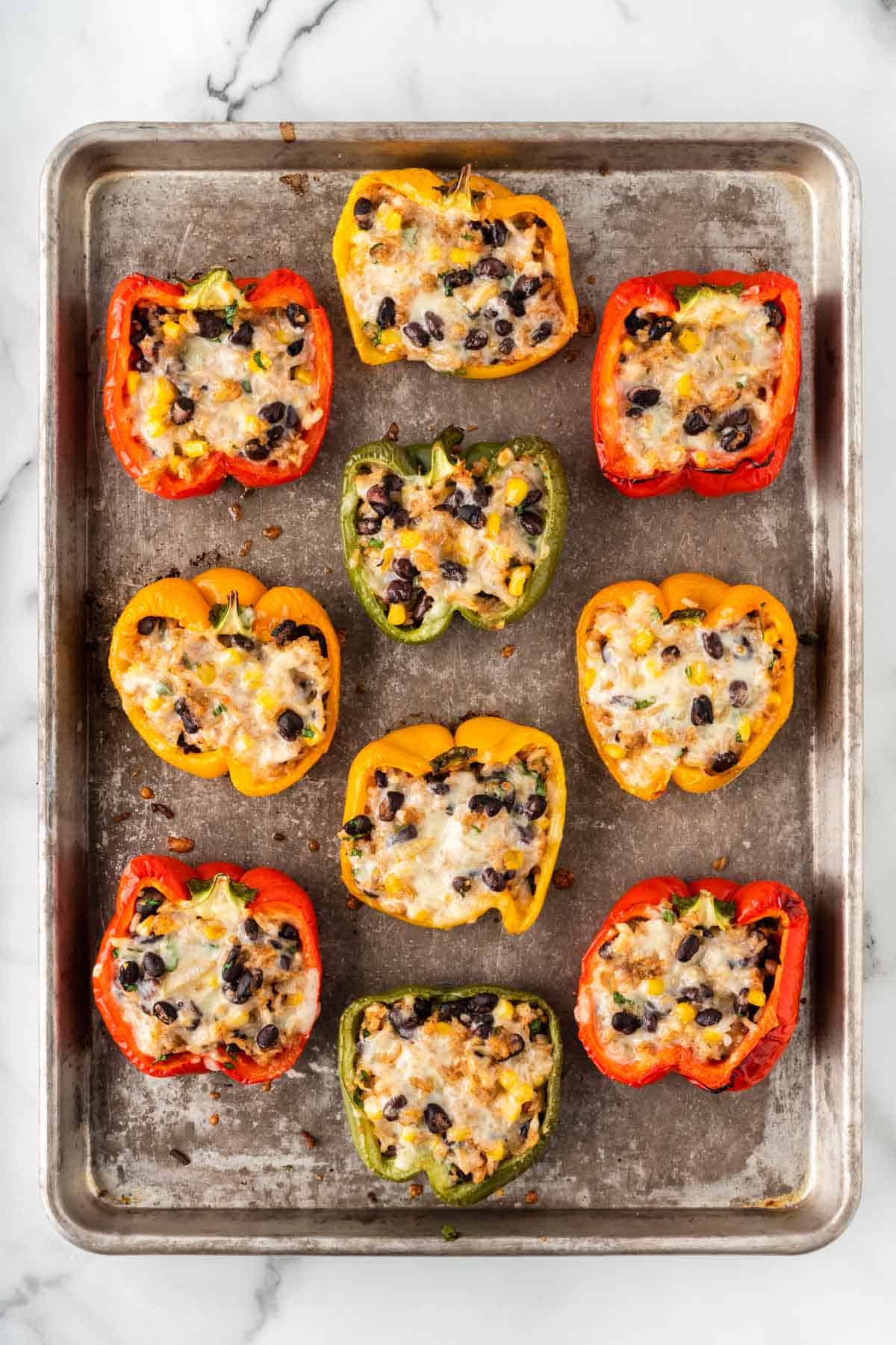 baked vegetarian stuffed peppers on a baking sheet