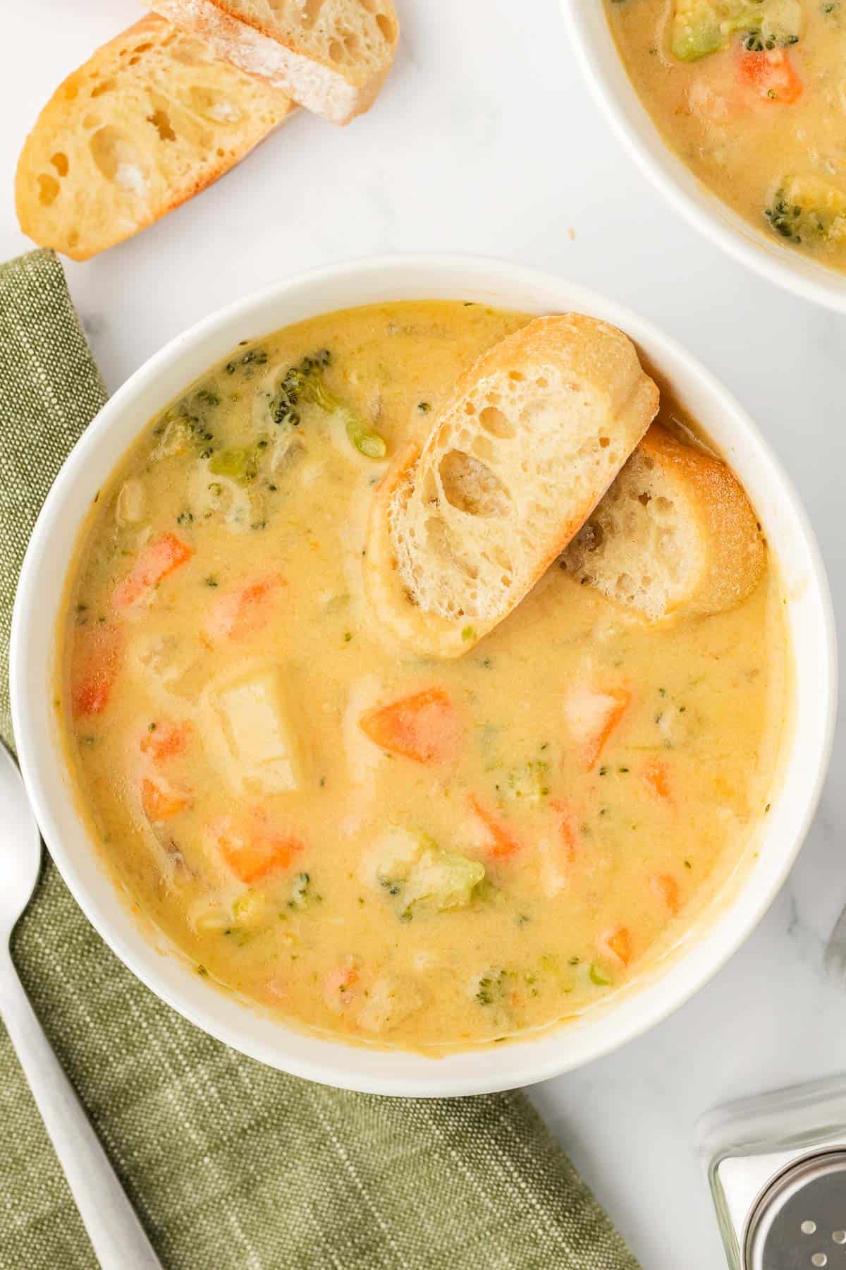 vegetable soup in a bowl with baguette slices