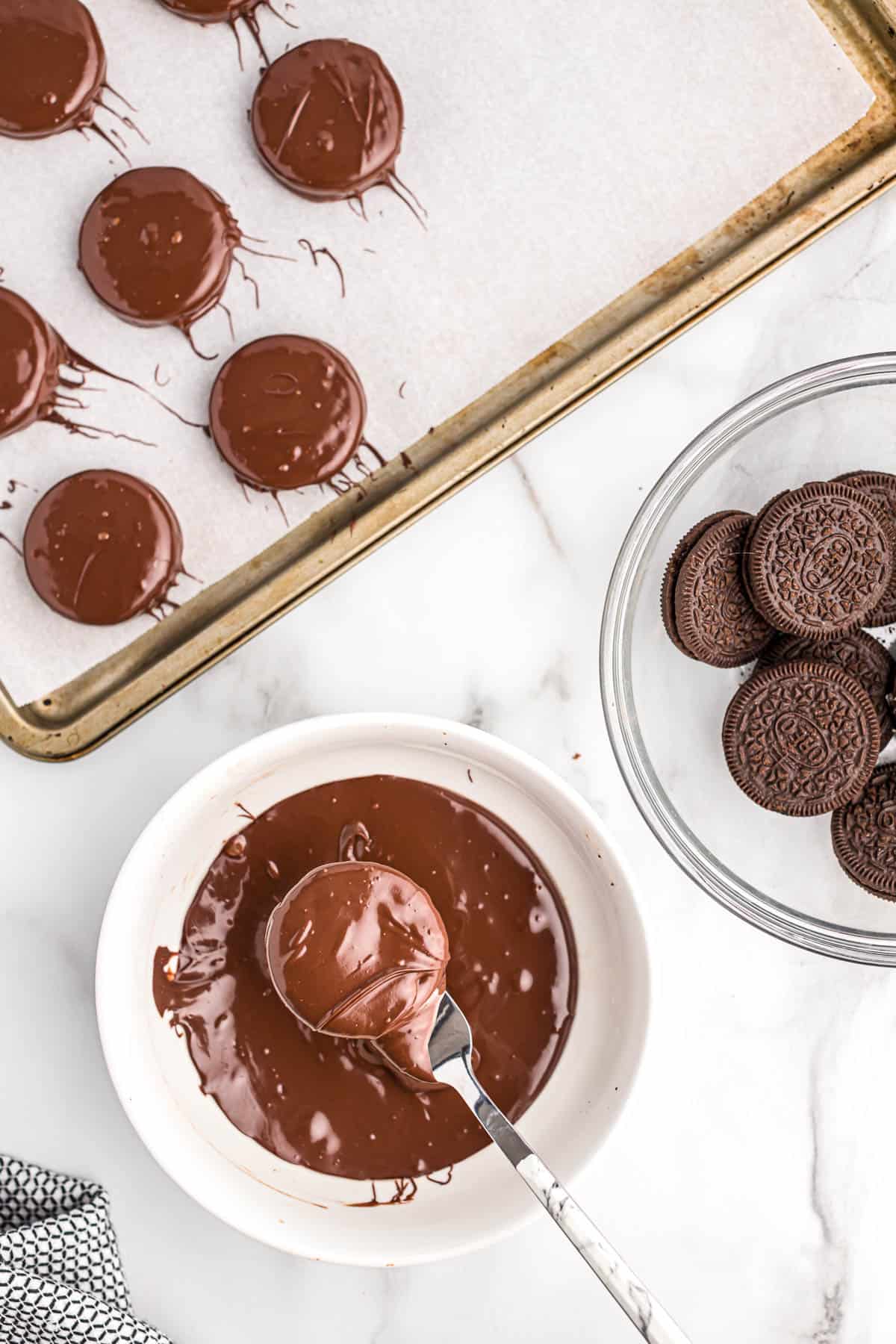 dipping an oreo into melted chocolate