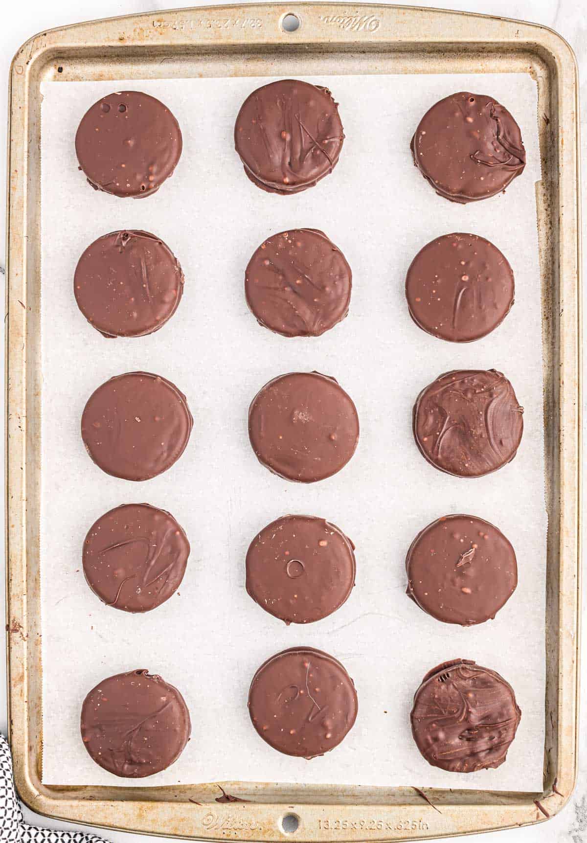 chocolate dipped oreos on a baking sheet