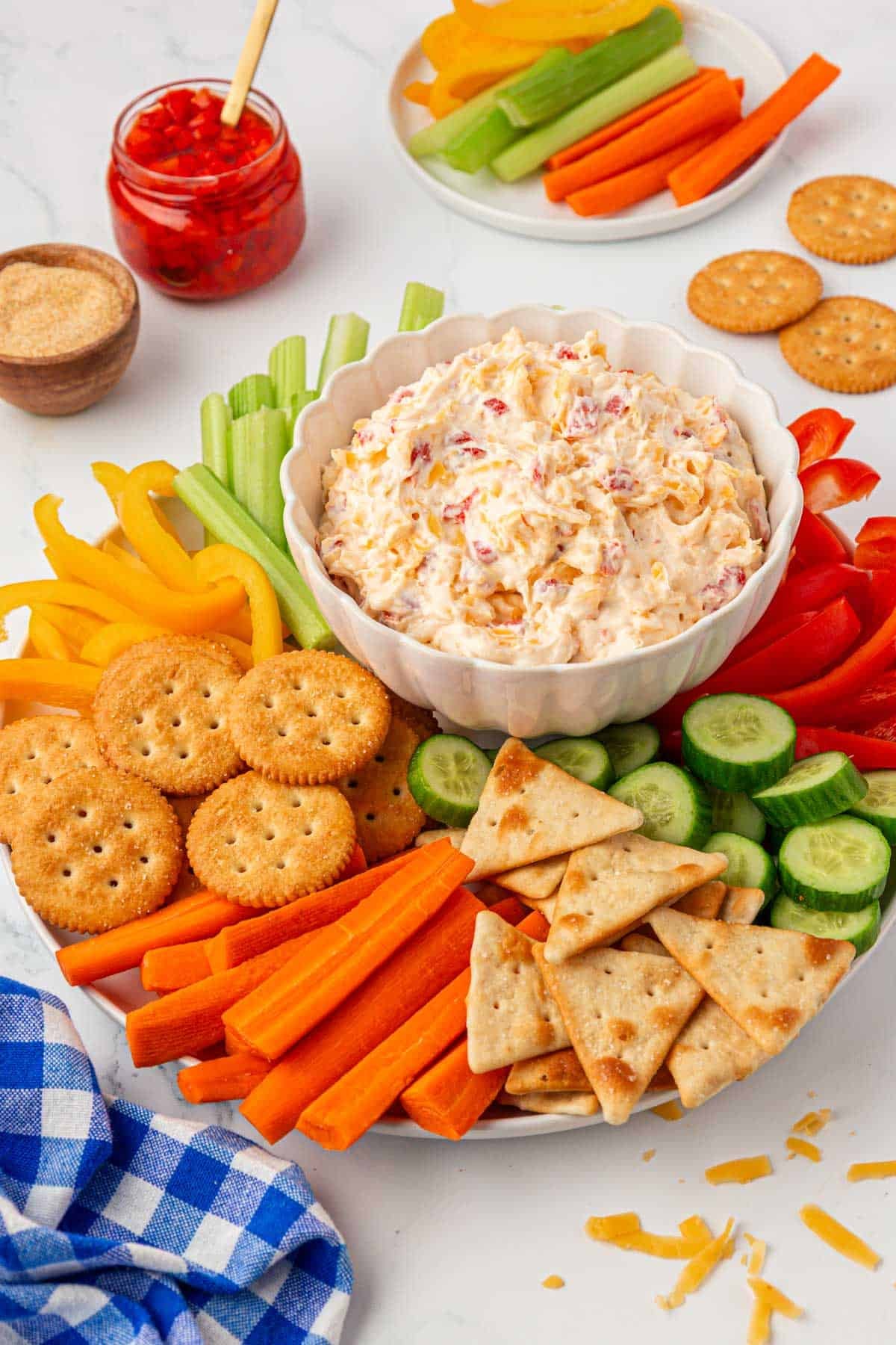 pimento cheese on a platter with crackers and cut up vegetables