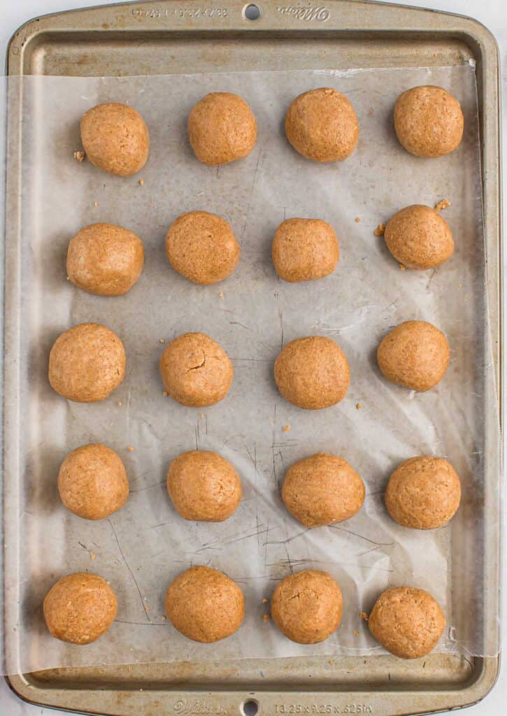 peanut butter balls on a lined baking sheet