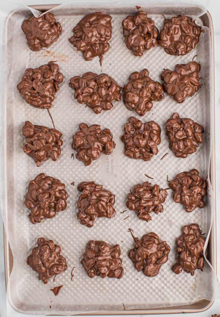 crock pot peanut clusters on a baking sheet
