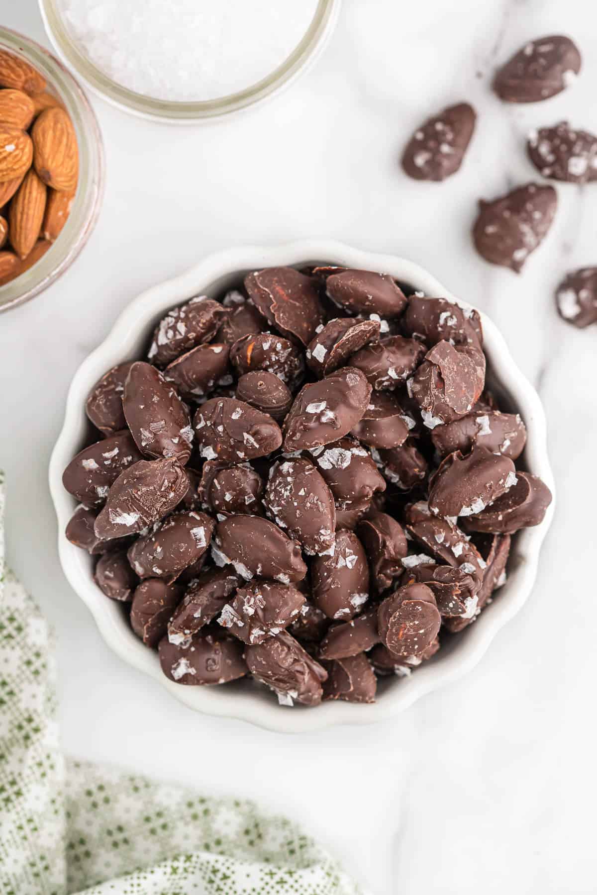 chocolate covered almonds with sea salt in a white bowl