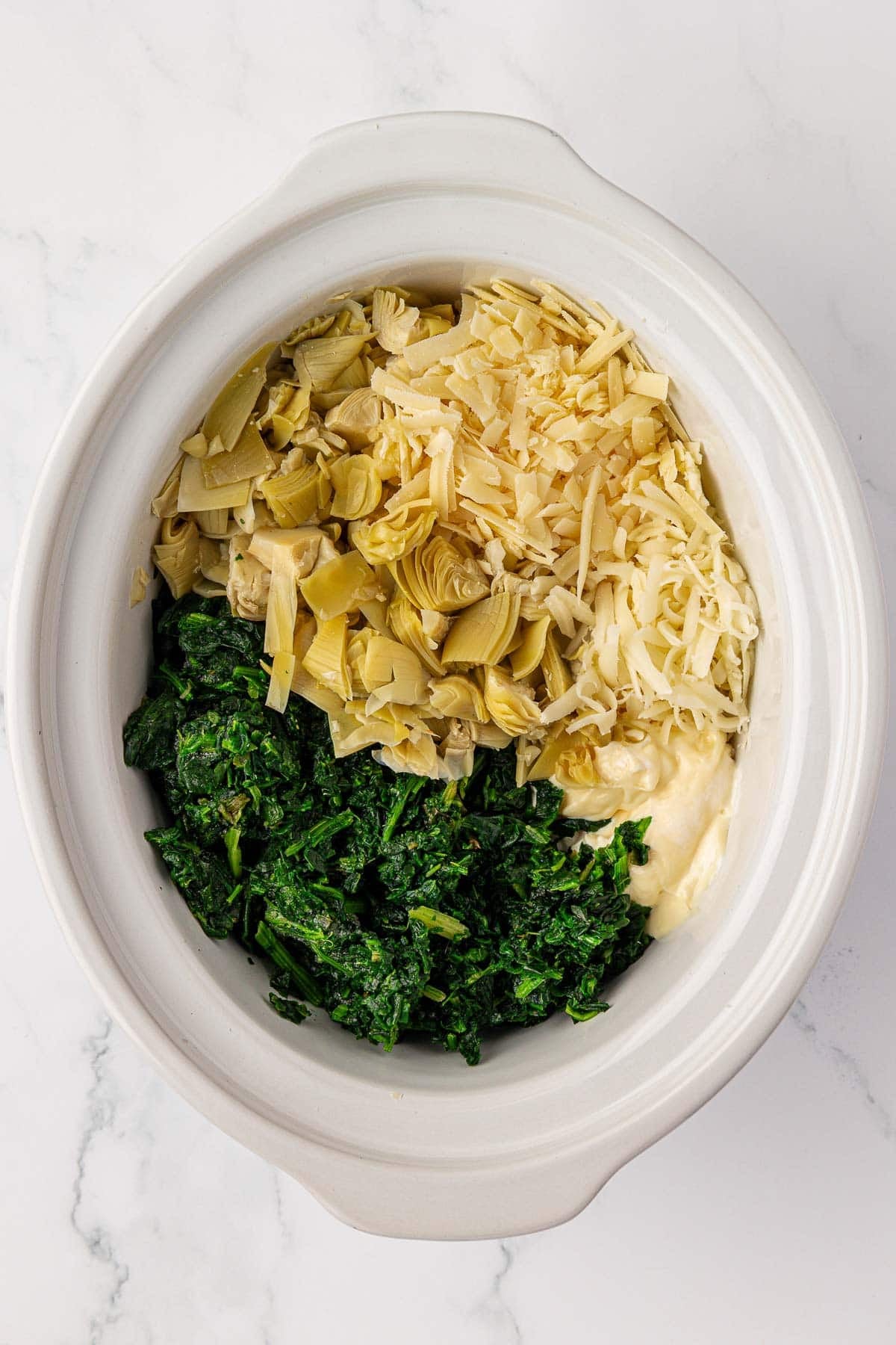 ingredients to make spinach artichoke dip in a slow cooker