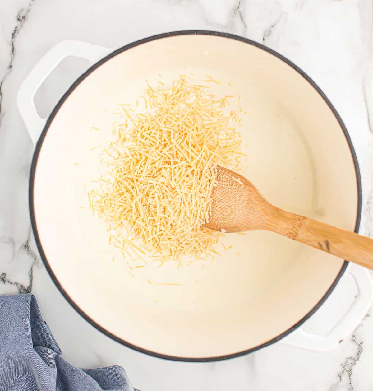 adding parmesan cheese to the cream sauce