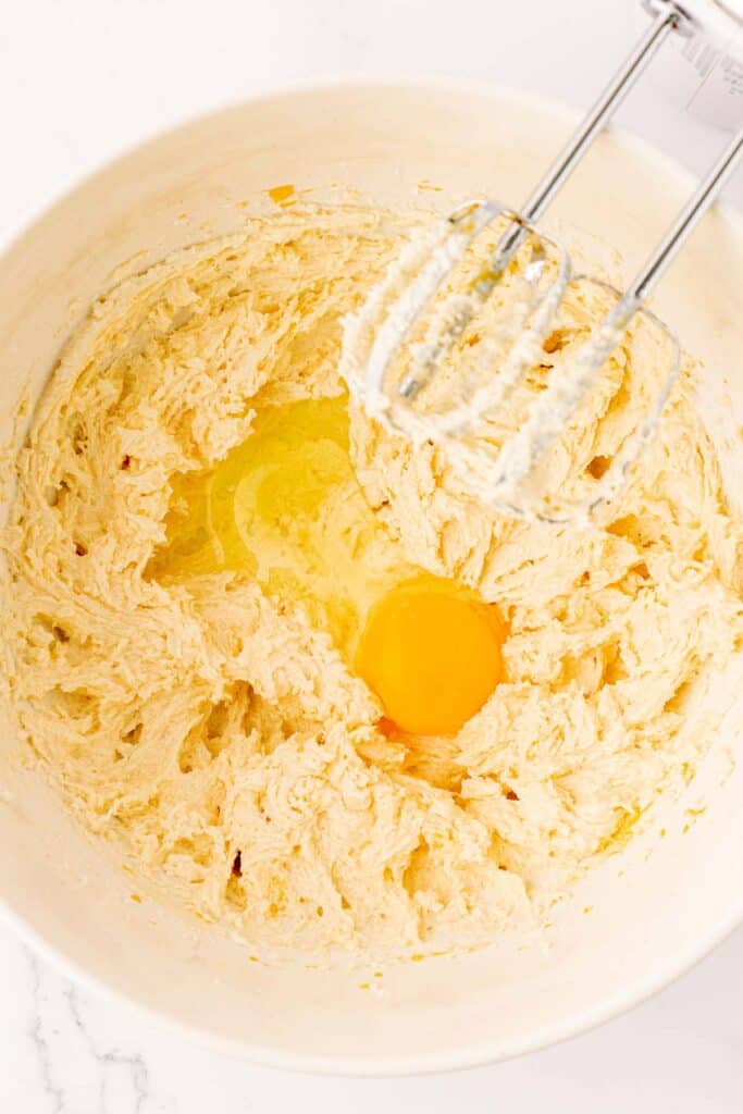 adding an egg to butter and sugar creamed together