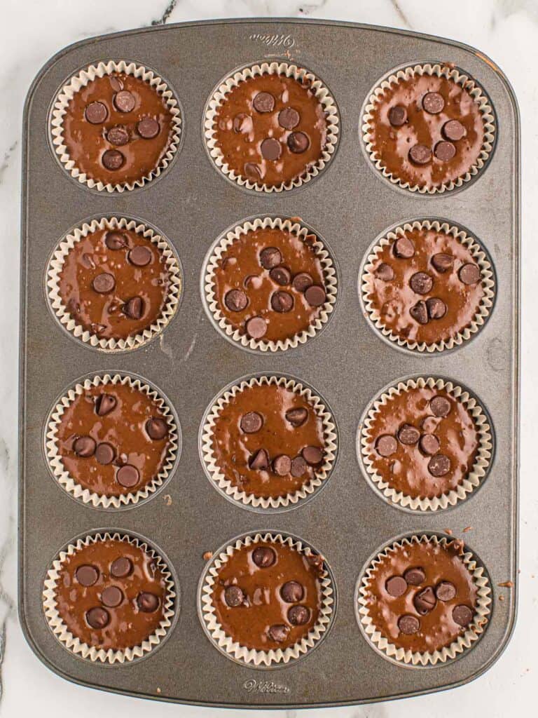 muffin tin filled with chocolate muffin batter