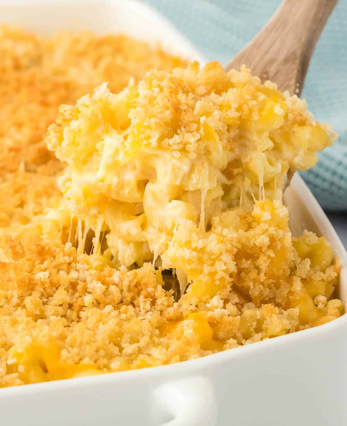 scooping mac and cheese from the baking dish