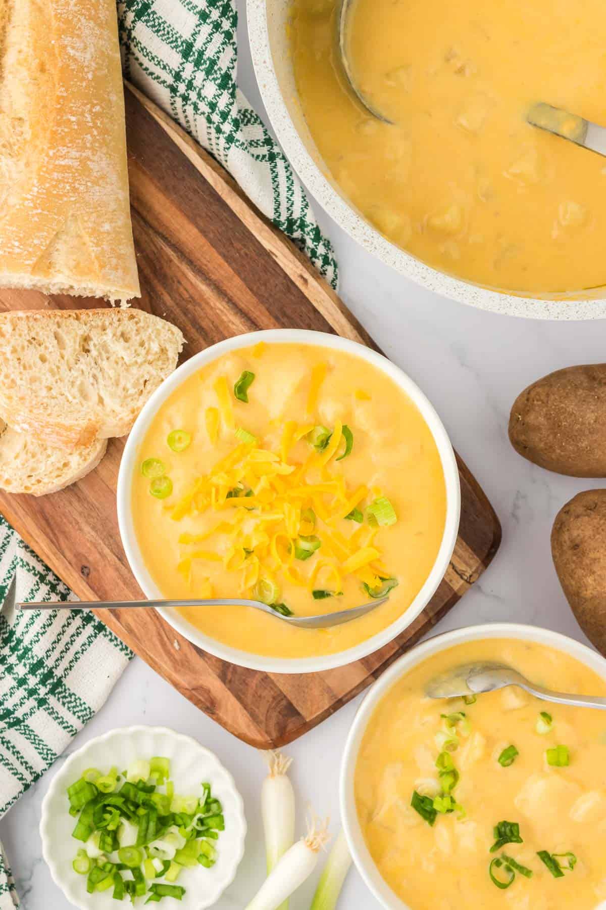 potato soup in a bowl topped with green onions and cheddar cheese