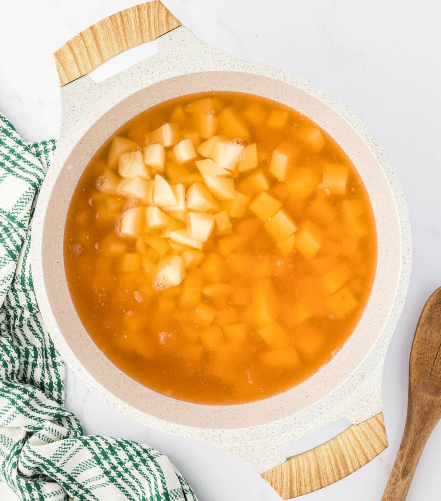 adding vegetable broth and potatoes