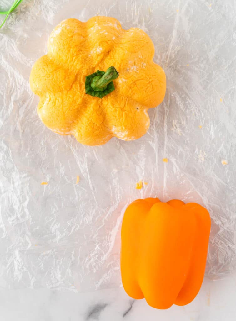 pumpkin shaped cheese ball with a bell pepper stem