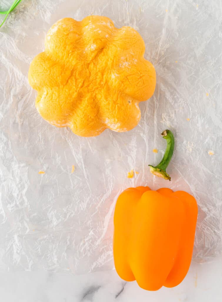 removing a stem from a bell pepper to place on the cheese ball