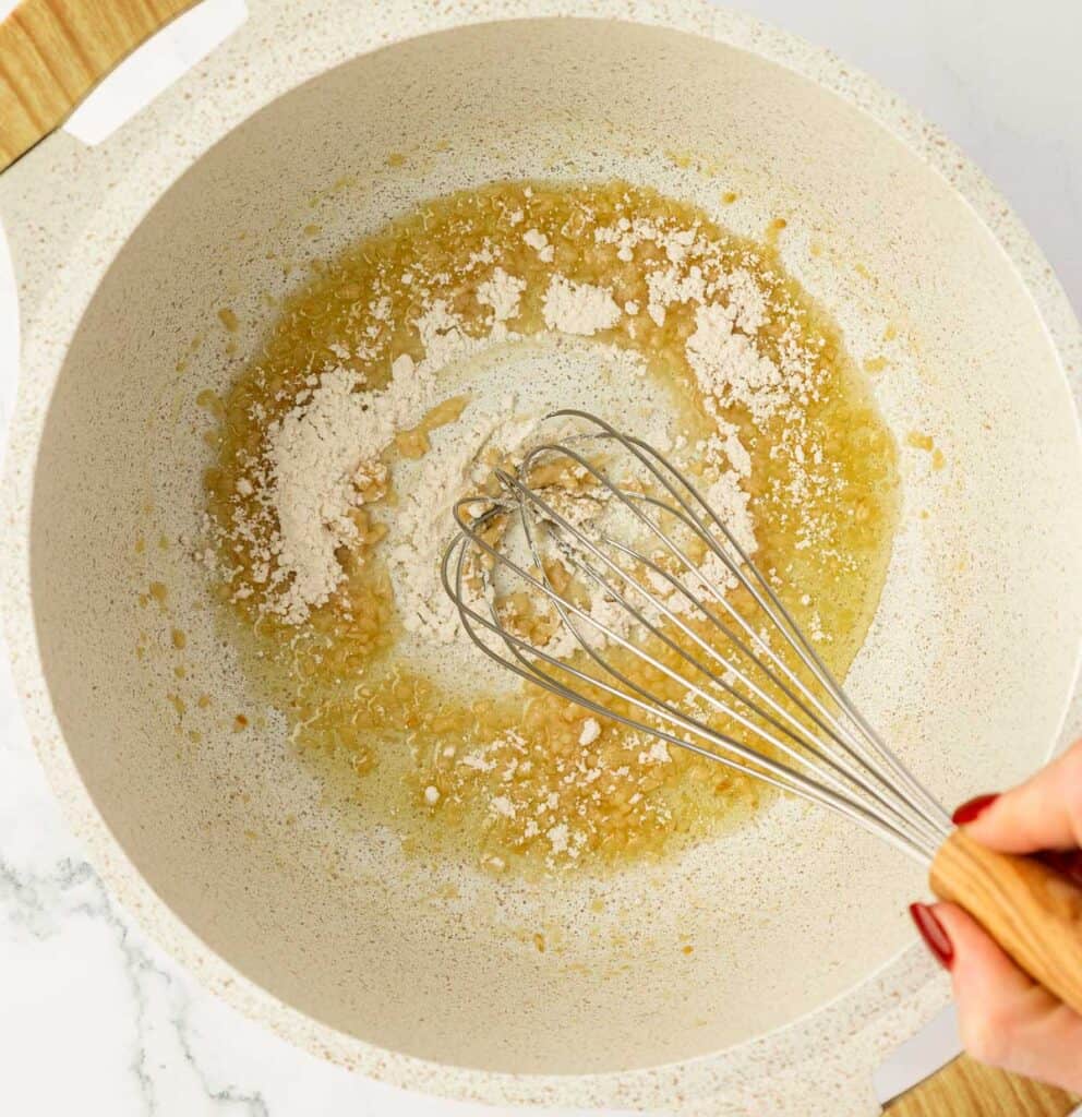 whisking flour into the butter and garlic