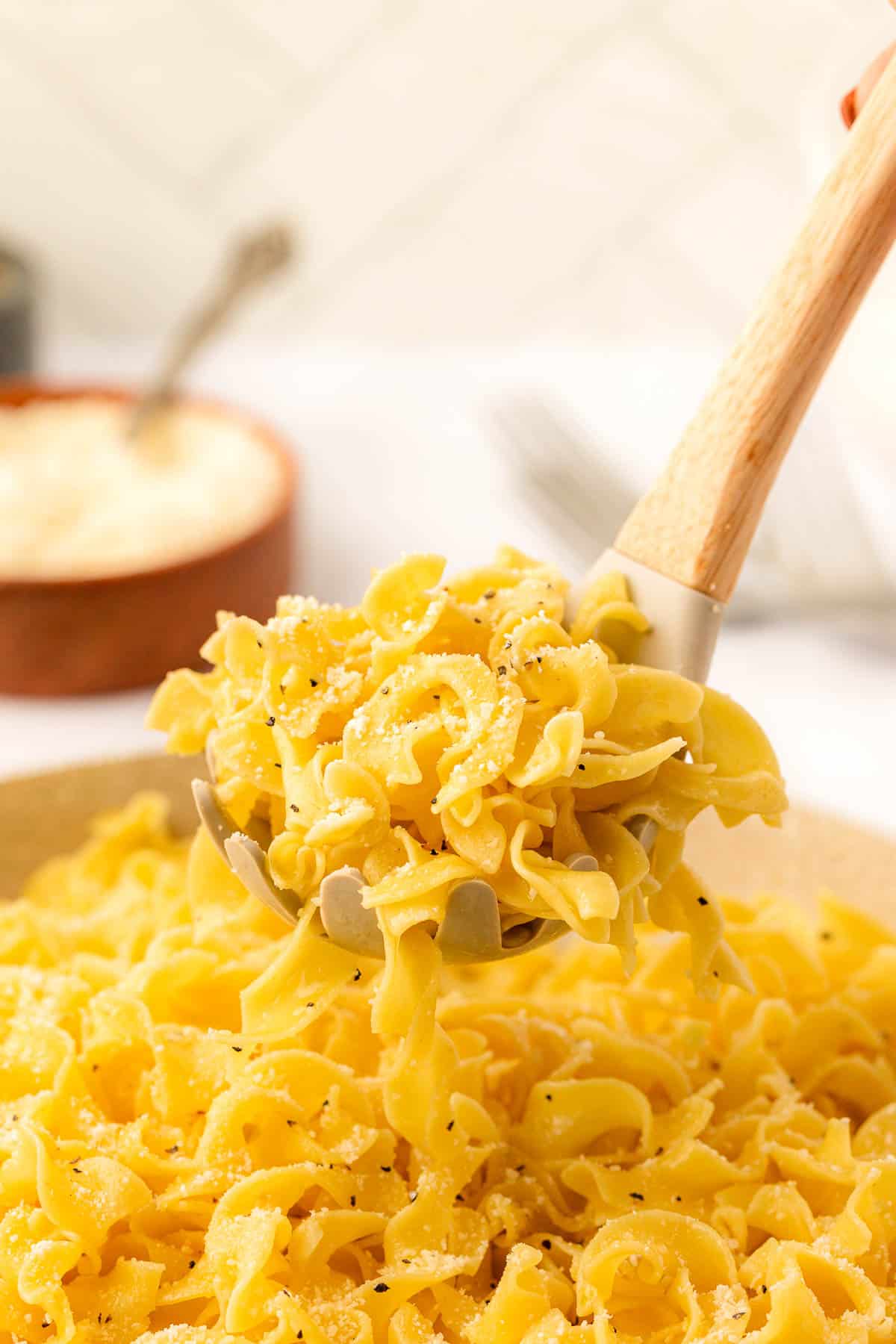 garlic butter noodles topped with pepper and parmesan cheese