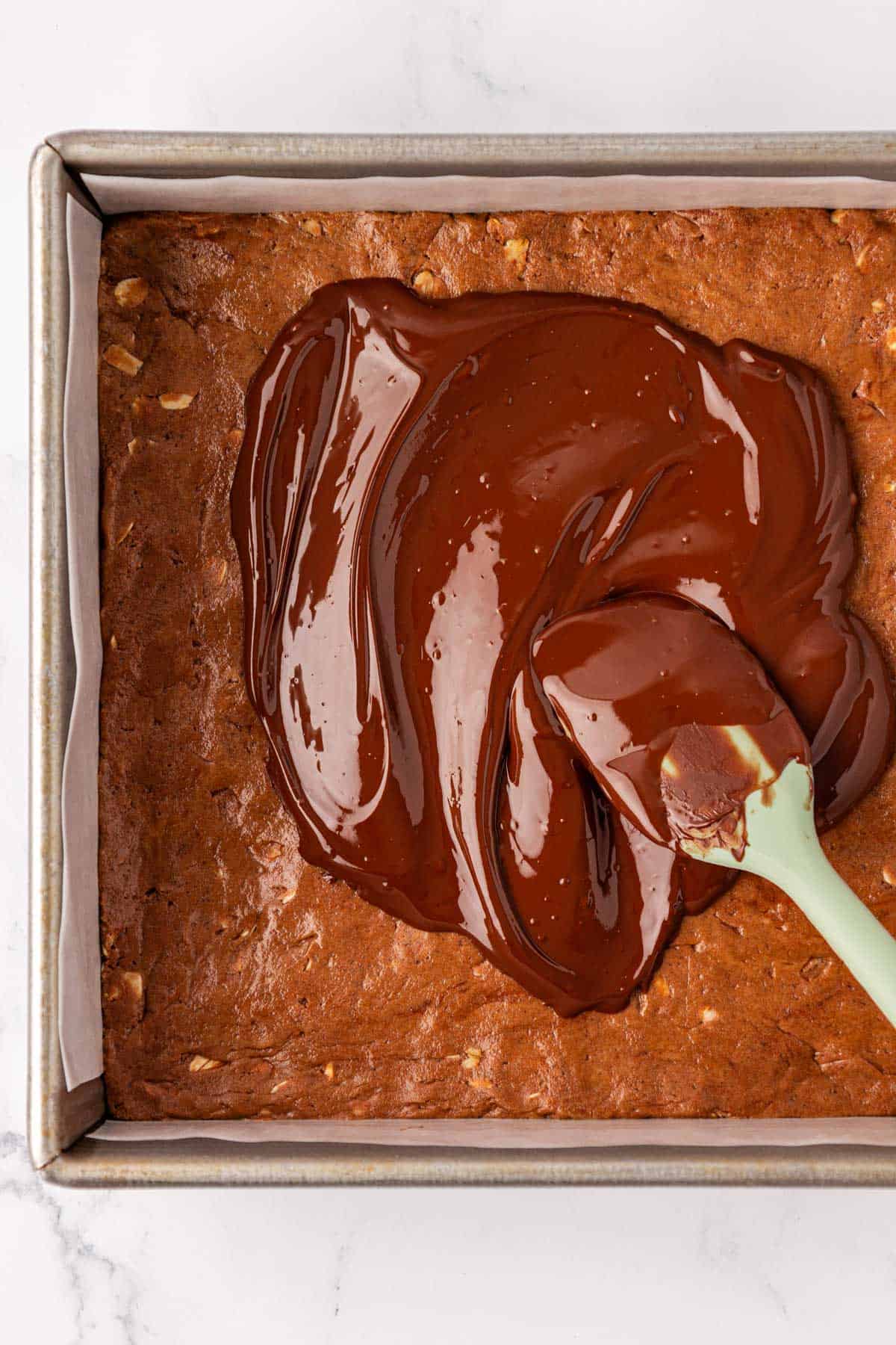 spreading the melted chocolate over the bars