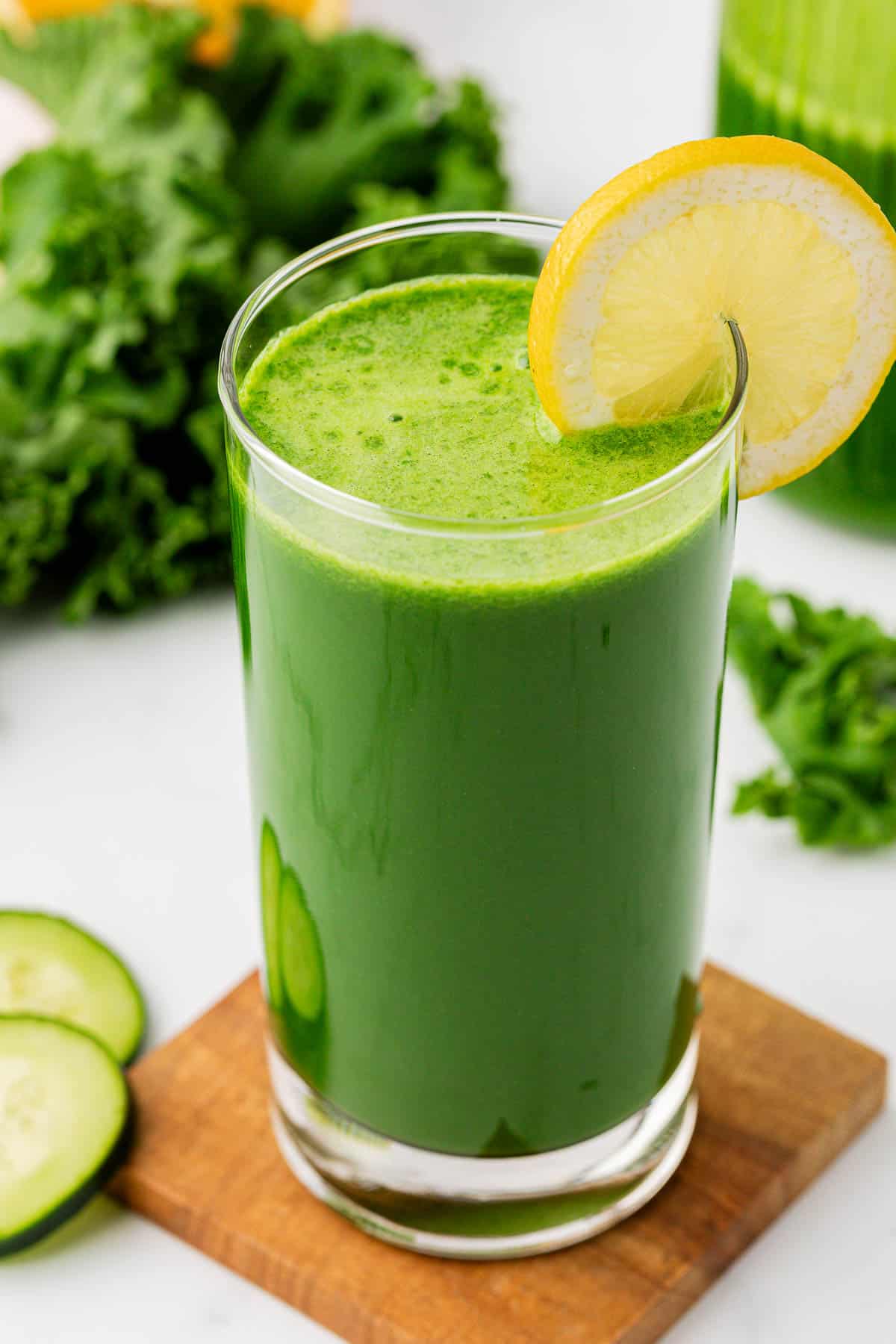 kale juice in a glass with a lemon slice on the rim