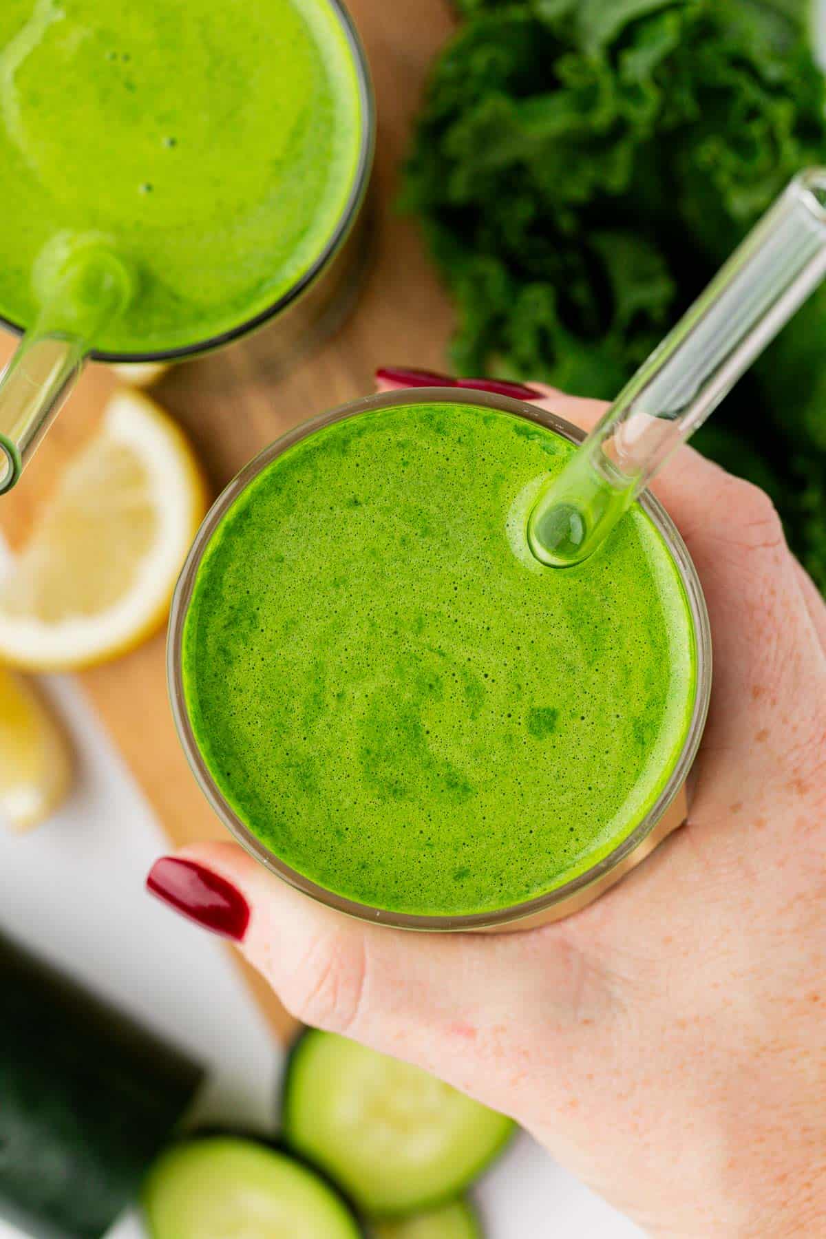 kale juice in a glass with a straw