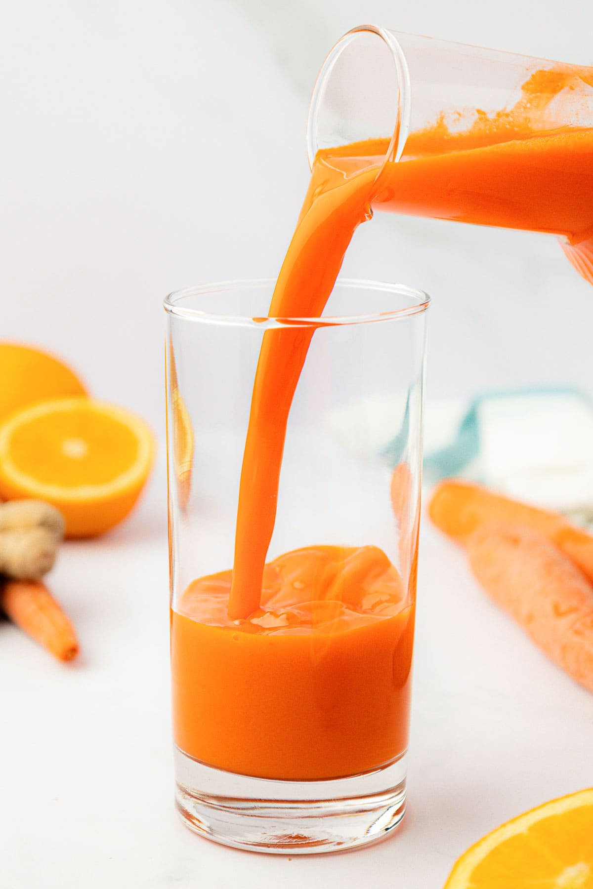 pouring carrot juice into a glass