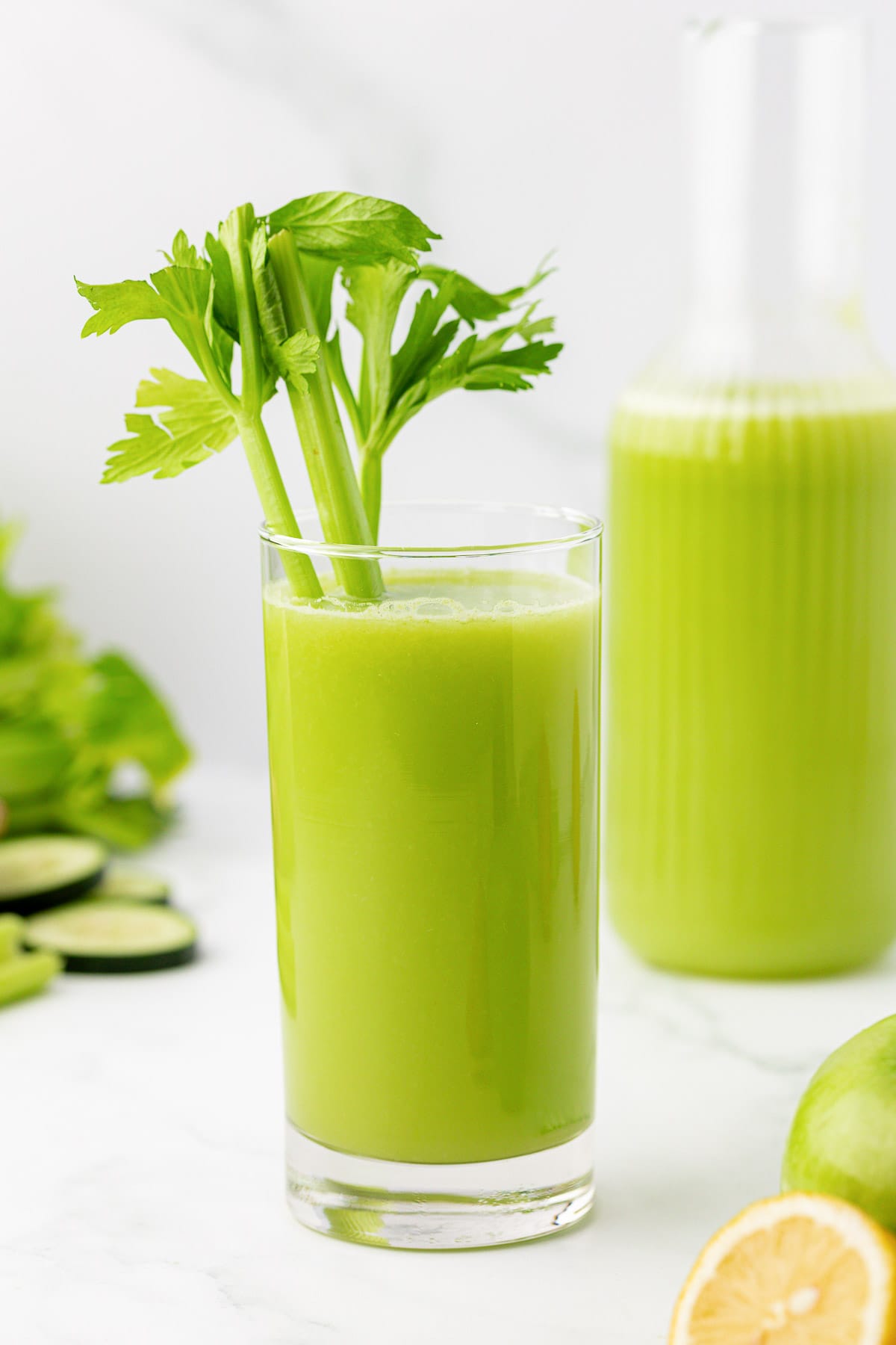 celery juice in a glass with celery in it