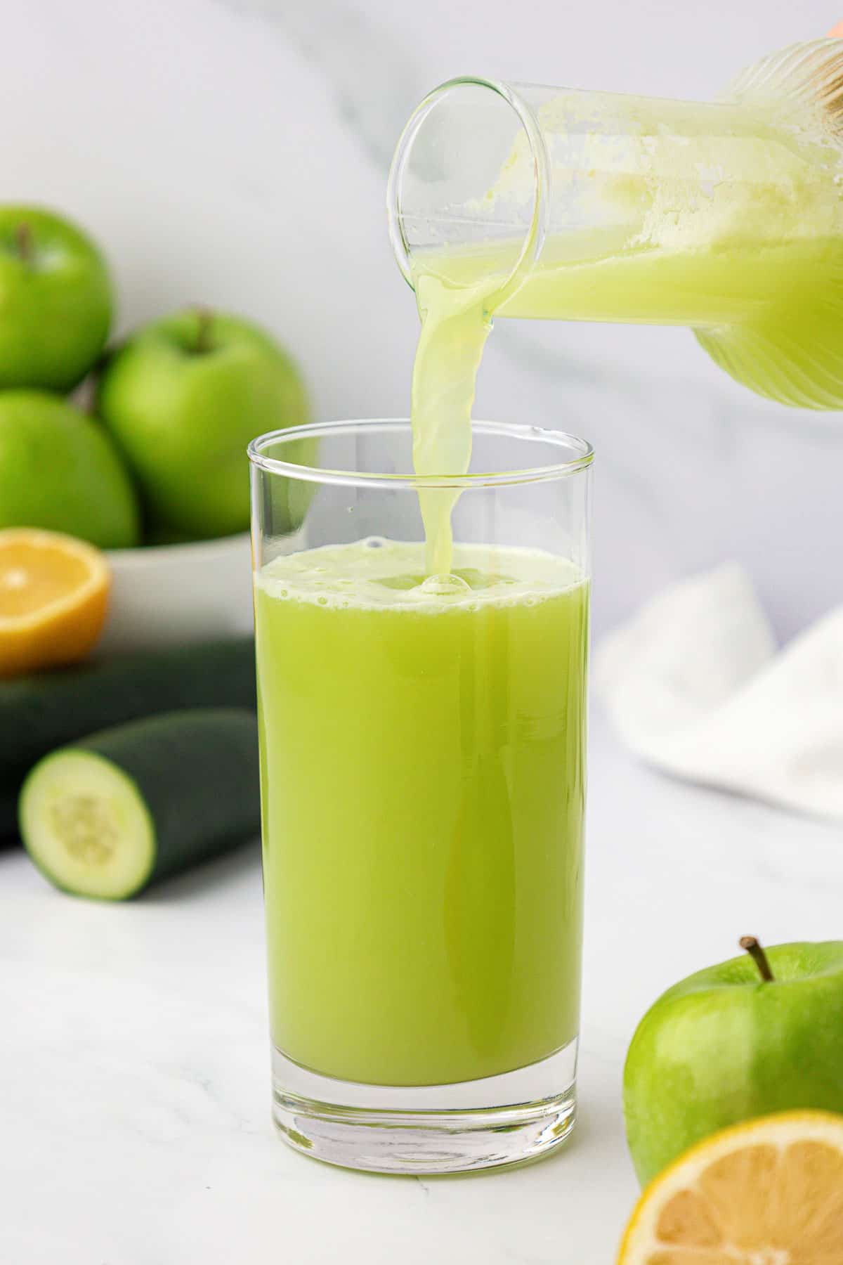 pouring green apple juice into a glass