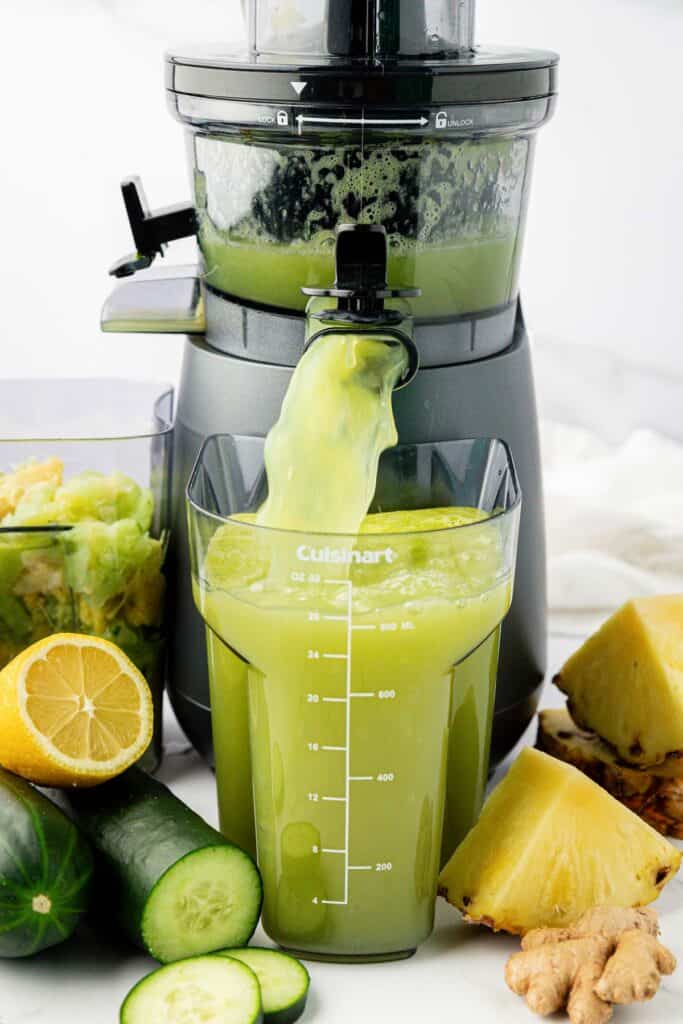 pineapple cucumber juice coming out of a juicer