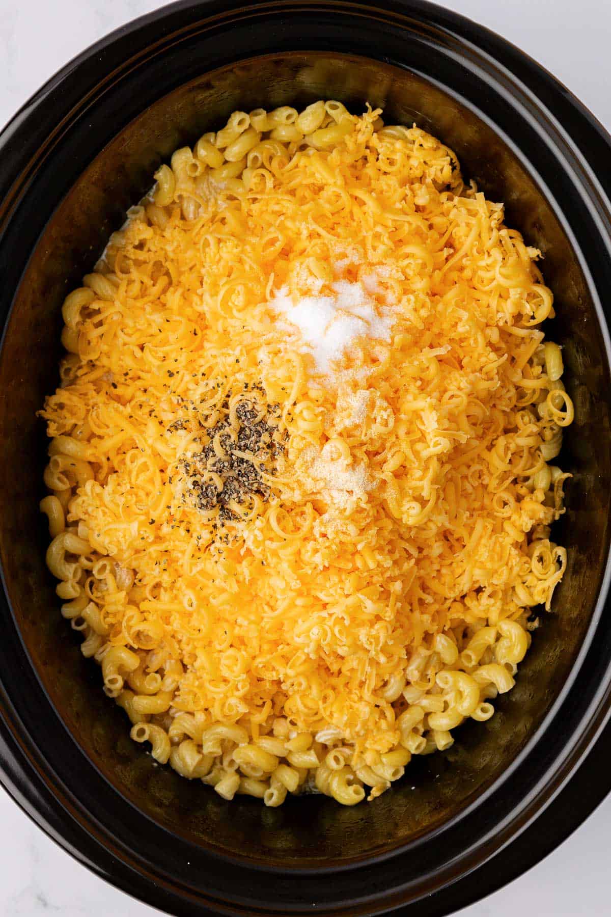adding the cheese and spices to the macaroni noodles