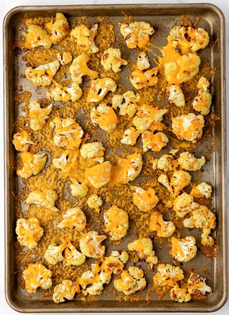 roasted cauliflower with cheese on a baking sheet