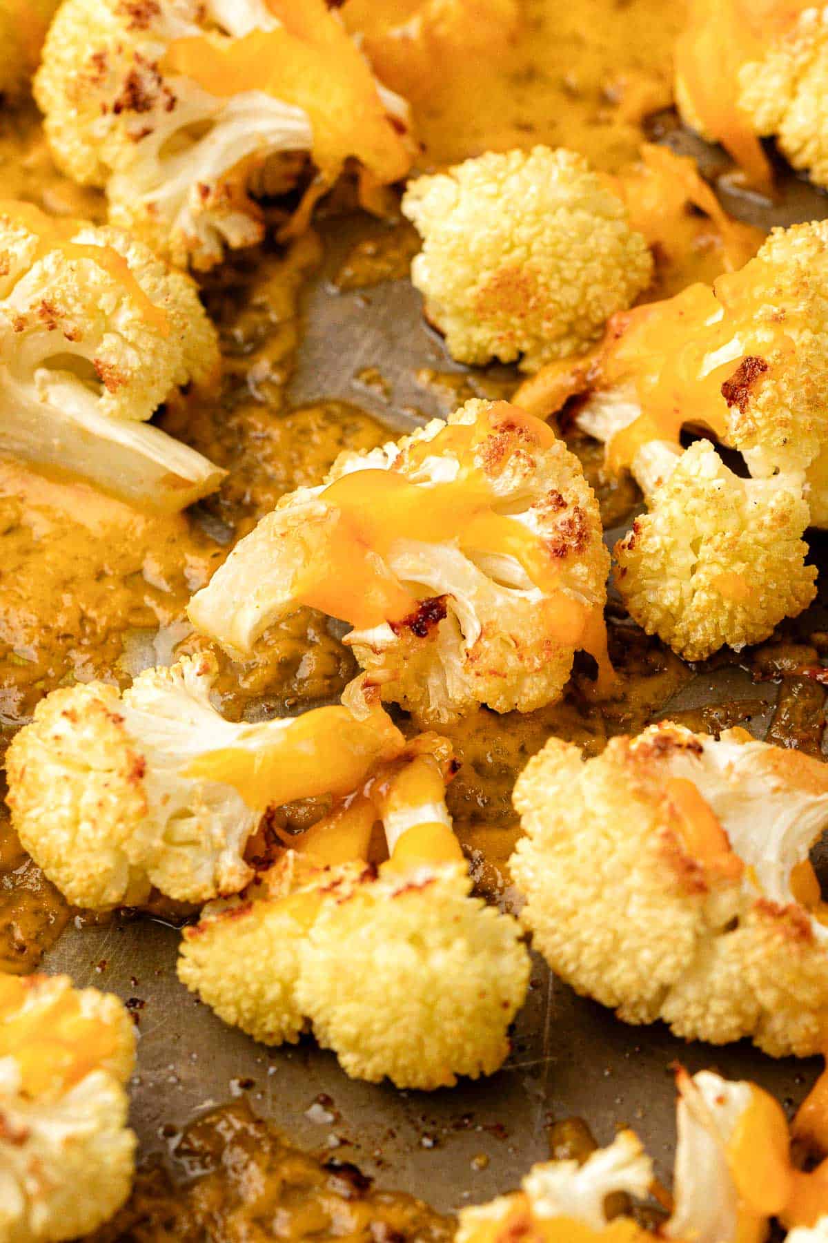 roasted cauliflower with cheese on a baking sheet