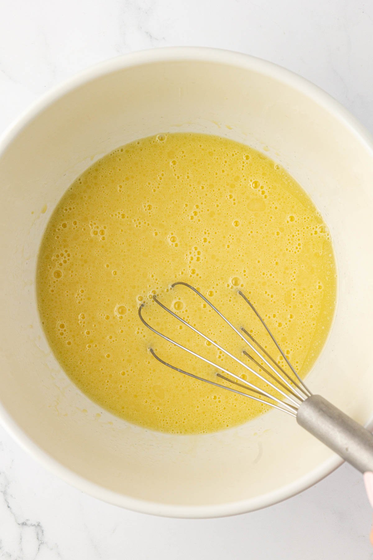 whisking butter and eggs in a bowl