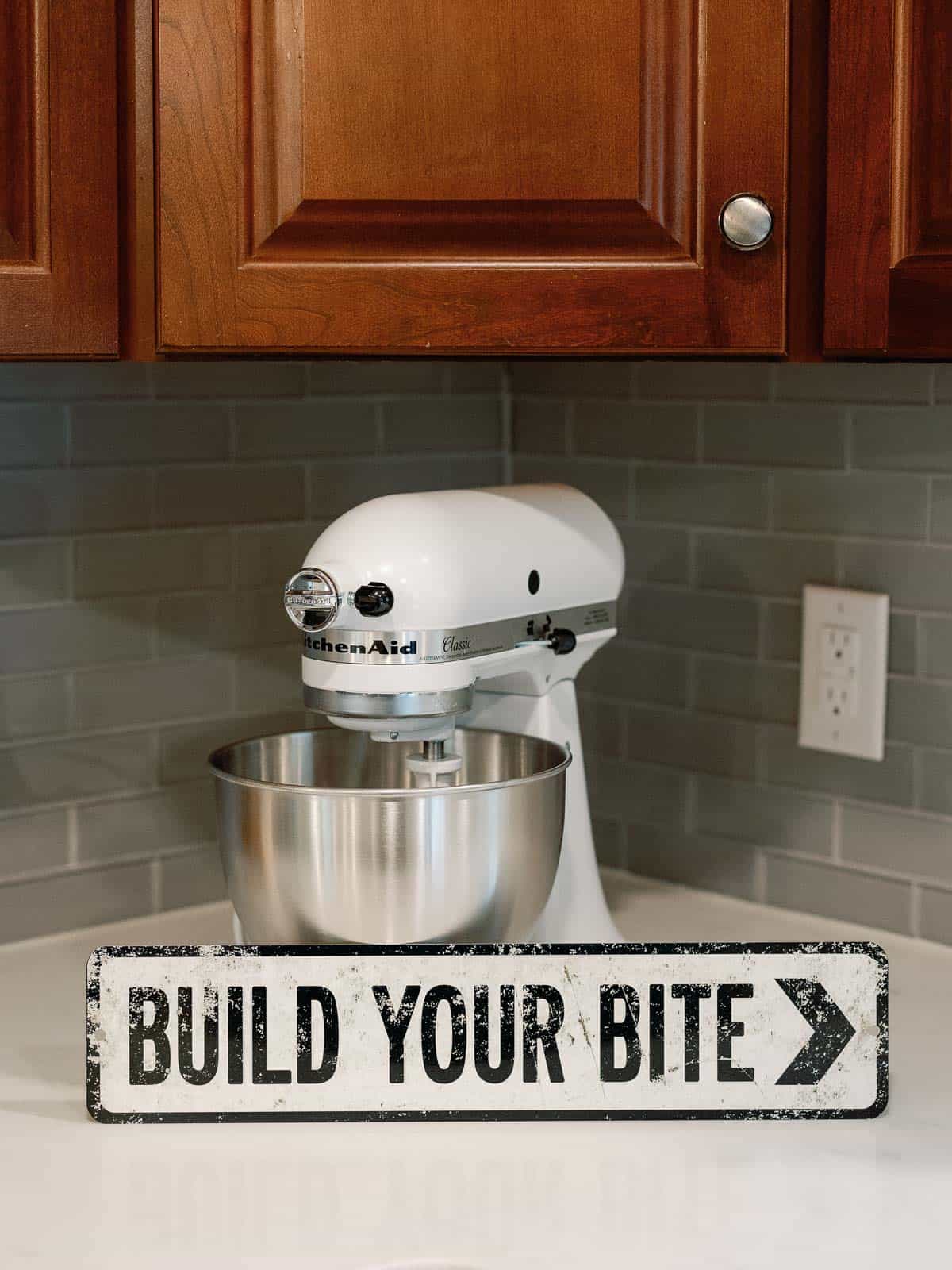 kitchenaid with a sign in front of it that reads "build your bite"