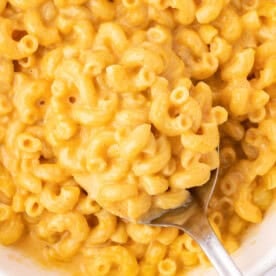 butternut squash mac and cheese in a bowl with a serving spoon