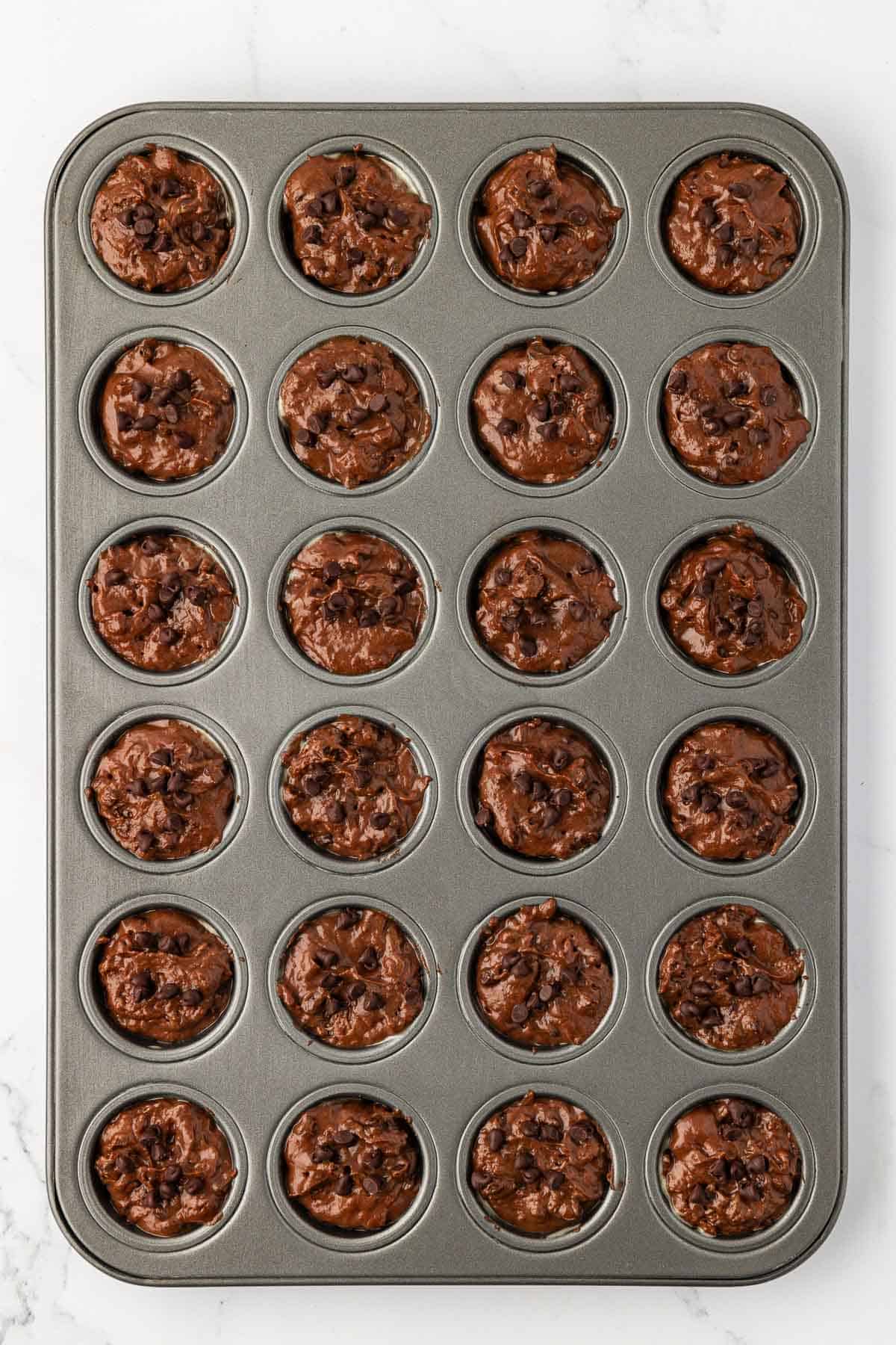 chocolate muffin batter in a mini muffin tin