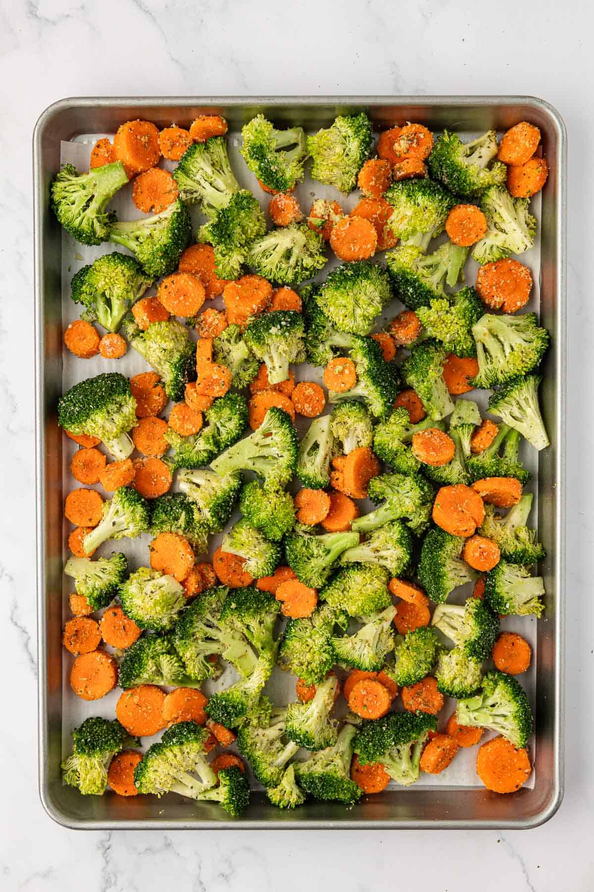 sliced carrots and broccoli florets on a baking sheet