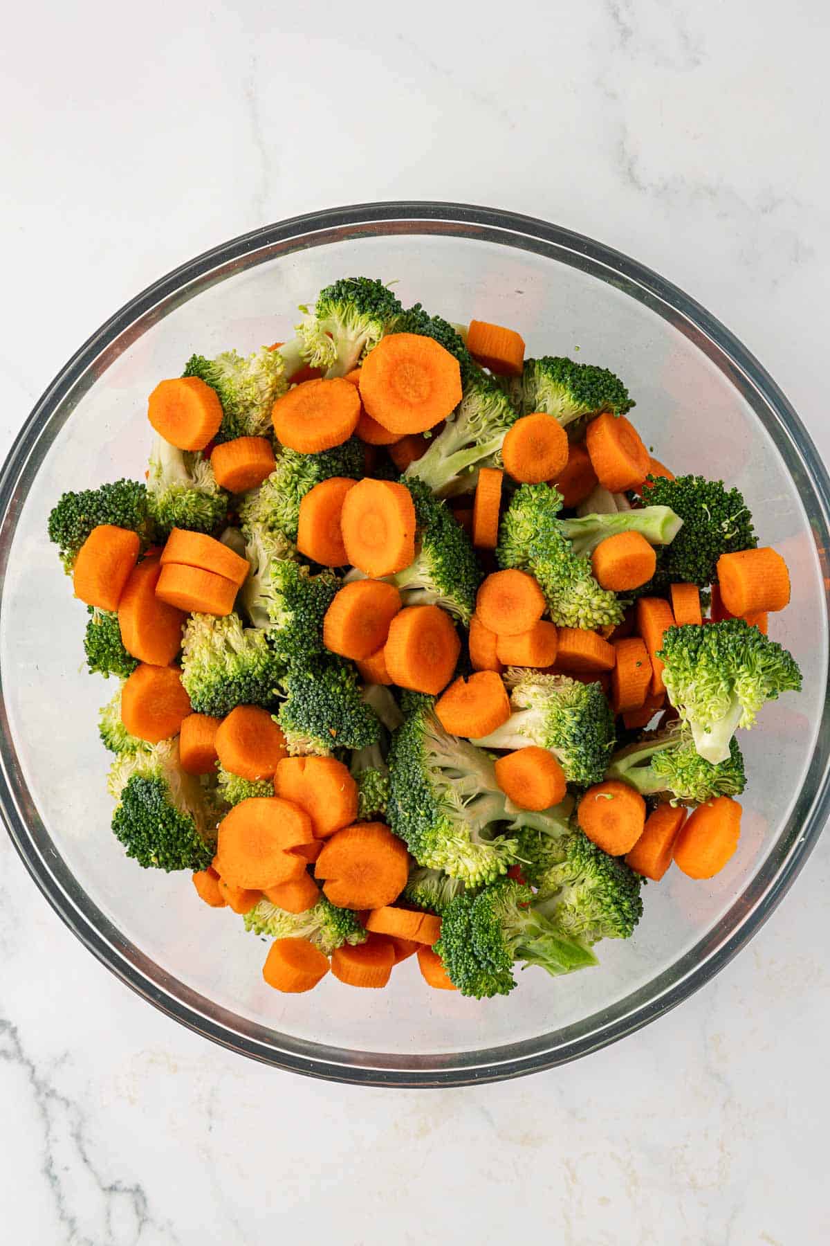 broccoli florets and sliced carrots in a mixing bowl