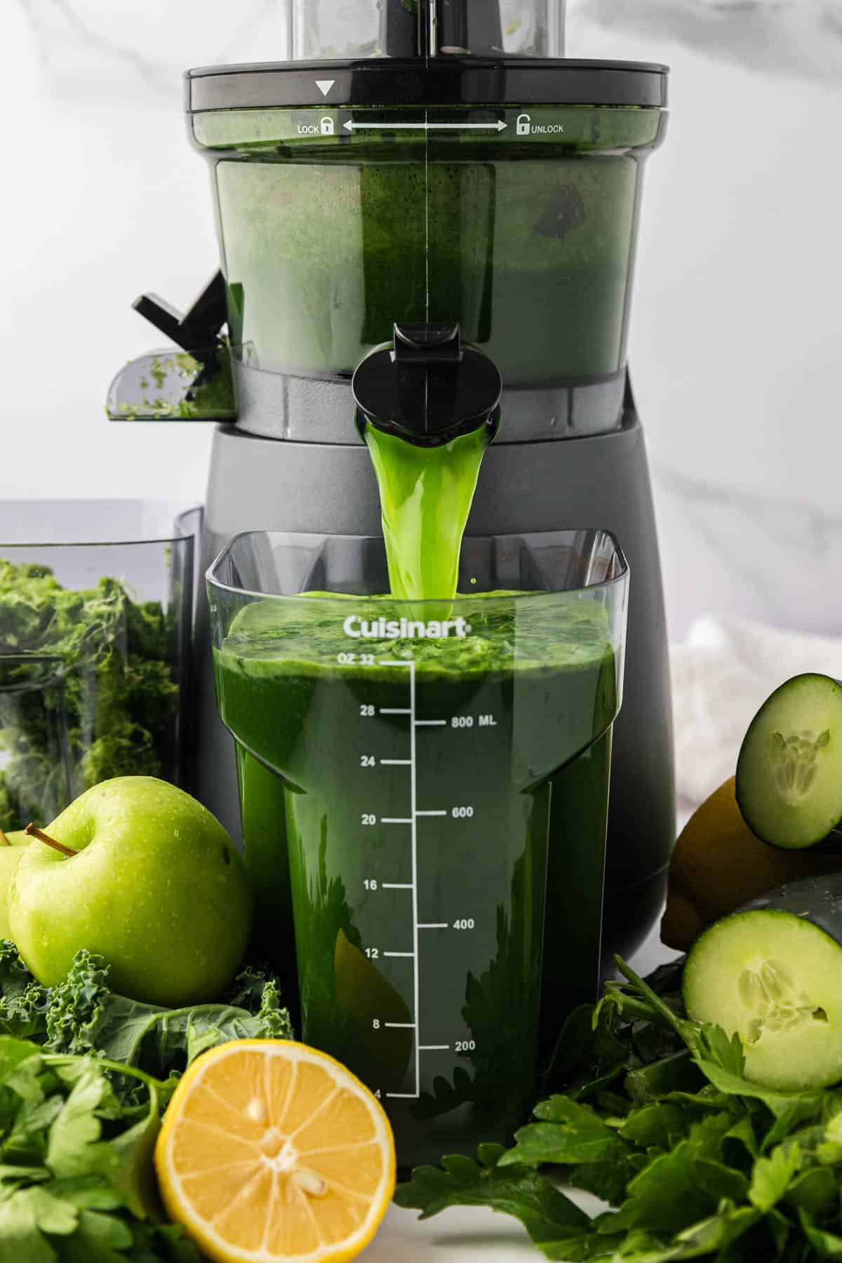 green juicing pouring out of a juicer